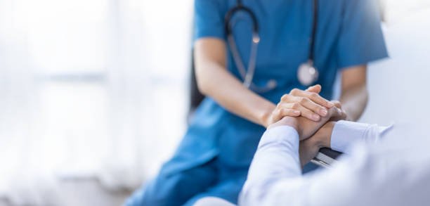 Cropped shot of a female nurse hold her senior patient's hand. Giving Support. Doctor helping old patient with Alzheimer's disease. Female carer holding hands of senior man